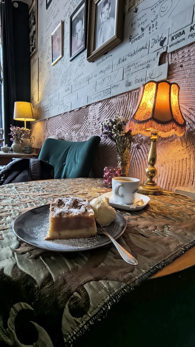 Szarlotka z lodami i kawa przy ścianie z autografami — Cafe Klaps